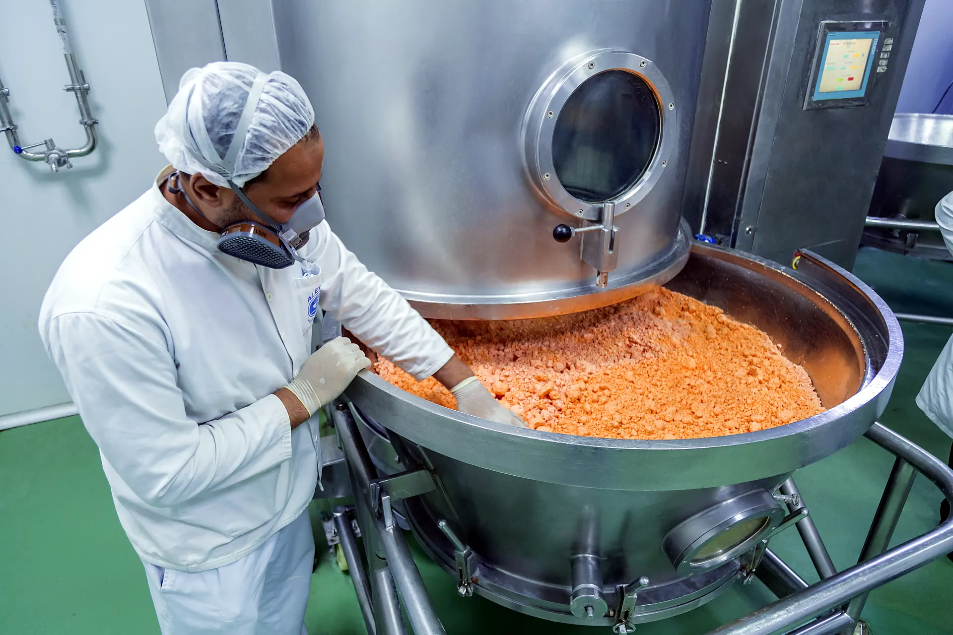 Operator checking granules in a fluid-bed dryer